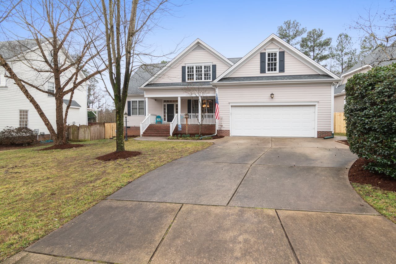 gallery-6 A well-maintained suburban house exterior with a large driveway, perfect for real estate listings.