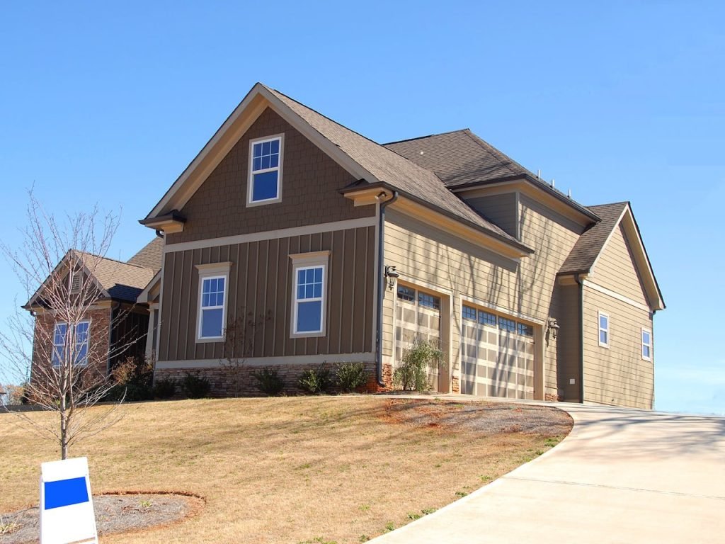 brown-and-beige-wooden-house-under-blue-sky-221540 Cozy family home for sale in suburb with spacious garage and landscaped lawn.