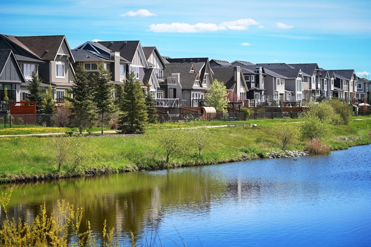 services-03 Modern suburban houses lining a serene pond in Airdrie, Alberta, Canada.